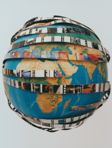 A globe with film strips wrapping around it, representing the globalization of the entertainment industry