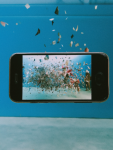 A smartphone screen expanding into a film screen, illustrating the convergence of mobile technology and cinematic entertainment