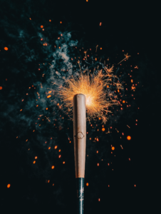 A baseball bat striking a ball that turns into fireworks, symbolizing the thrill of hitting a home run