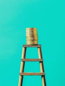 A career ladder made of giant coins stacked on top of each other, symbolizing financial growth as a key part of career progression