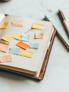 A close-up of a journal open to a page with sticky notes containing affirmations, illustrating a reflective practice of self-love