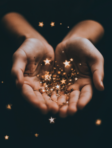 A cluster of bright stars glowing in someone’s hands, symbolizing holding many possibilities or talents