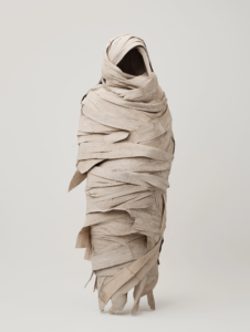 A human figure wrapped in a cocoon made of bandages, symbolizing the transformation and recovery process in healthcare