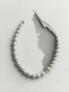 A strand of pearls turning into a constellation of stars, symbolizing the timeless and universal appeal of classic beauty