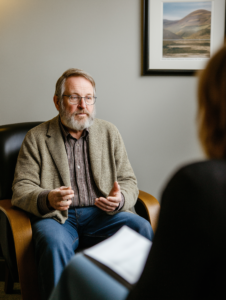 A therapist sitting with a client, discussing addiction in a safe and supportive environment