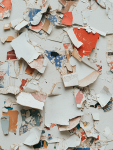 Torn political campaign posters scattered on a wall, symbolizing political rivalry, lost campaigns, or change